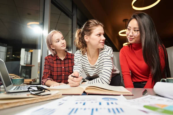 Bir grup genç, kahve dükkanında otururken ekip halinde edebiyat kitabından bilgi öğreniyor