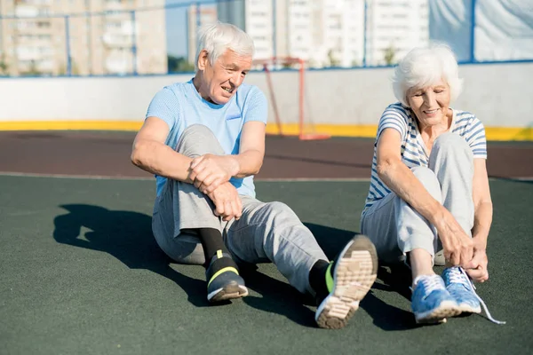 Potret Pasangan Senior Berambut Putih Mengikat Sepatu Olahraga Duduk Trek — Stok Foto