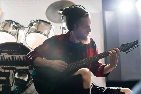 리허설 스튜디오에서 기타를 연주하는 남자의 초상화를 허리까지 — 스톡 사진