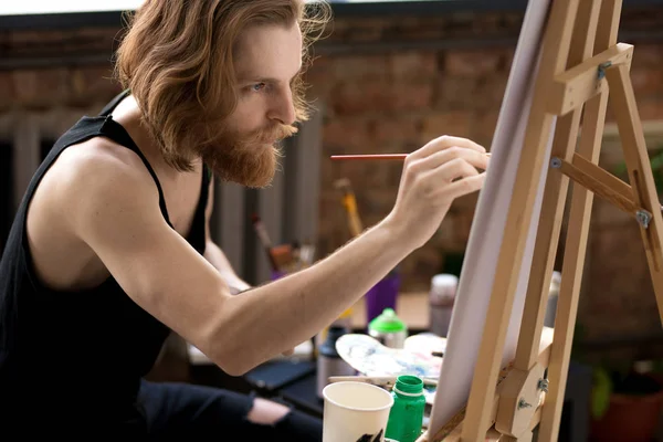 Zijaanzicht Portret Van Knappe Langharige Kunstenaar Holding Borstel Schilderij Schildersezel — Stockfoto