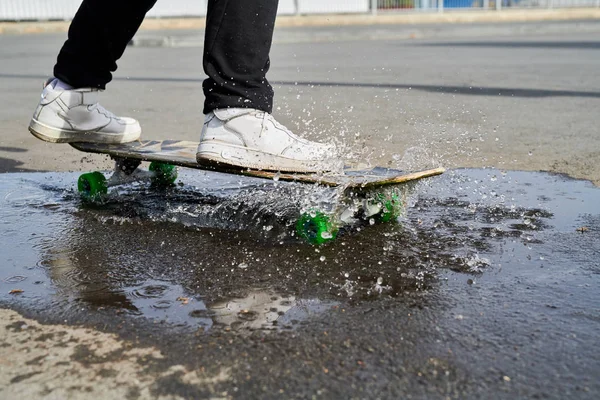 Låg Sektion Porträtt Oigenkännlig Tonåring Ridning Skateboard Över Pöl Med — Stockfoto