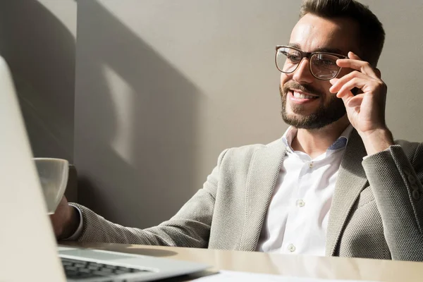 Sorrindo Gerente Barbudo Óculos Sentados Mesa Olhando Para Monitor Laptop — Fotografia de Stock