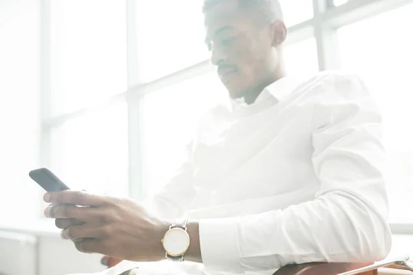 Серьезный Беззаботный Молодой Афроамериканский Бизнесмен Белой Рубашке Сидящий Стуле Использующий — стоковое фото