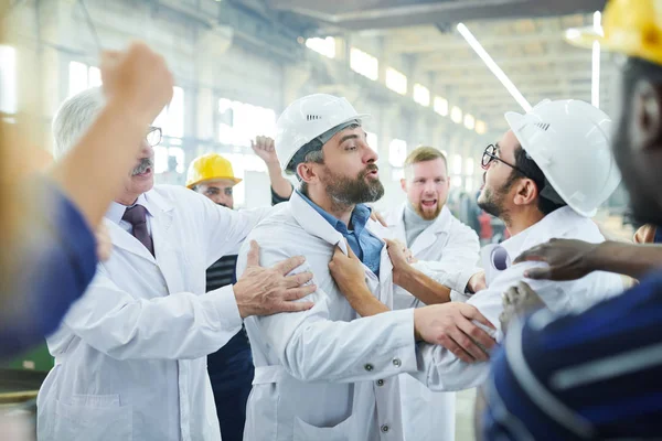 産業ワークショップでの会議中に怒っている労働者に話す2人の成熟した工場経営者の肖像画 — ストック写真