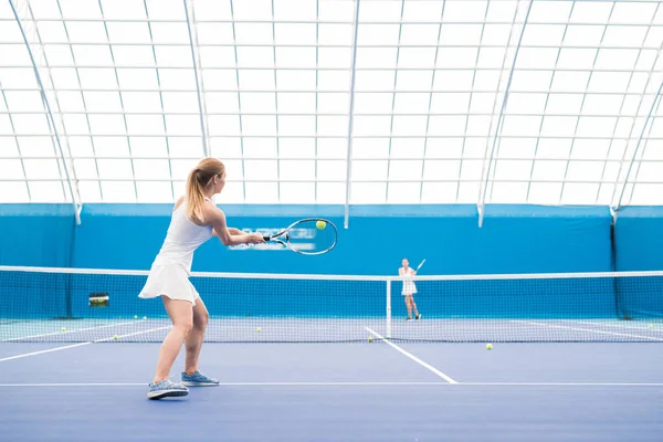 コートでテニスをプレイしながらボールを打つ若いスポーツウーマンの広角ポートレート コピースペース — ストック写真