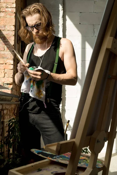 햇빛에 스튜디오에서 이젤에 그림동안 브러시를 예술가의 초상화 — 스톡 사진