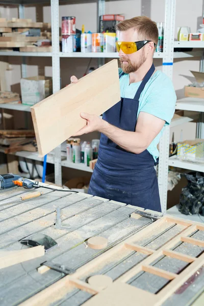 Young Concentrated Carpenter Standing Table Examining Smooth Piece Wood Joinery — 스톡 사진