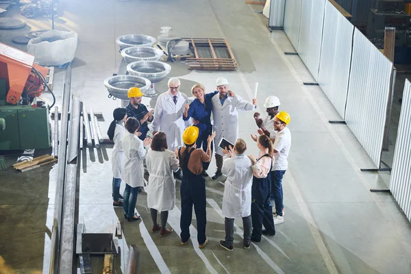 一群快乐的工厂工人在大型工业车间与管理层会面时鼓掌 复制空间 — 图库照片