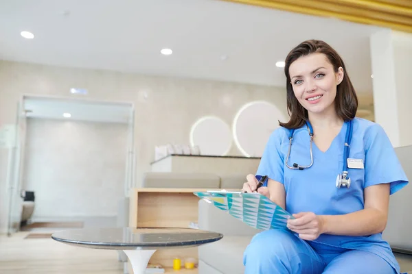 Retrato Una Médica Sonriente Mirando Cámara Mientras Está Sentada Sala — Foto de Stock