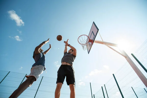 Bajo Ángulo Dos Jóvenes Jugando Baloncesto Saltando Por Aro Contra — Foto de Stock