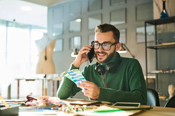 Retrato Del Joven Guapo Hablando Por Teléfono Mientras Sostiene Muestras —  Fotos de Stock