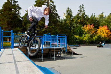 BMX bisiklet kaykay parkta rampa aşağı gidiyor stunts yapıyor modern genç adam tam uzunlukta portre, kopya alanı