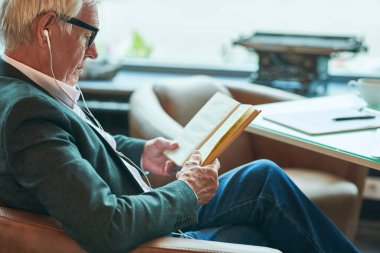 Kahve molası sırasında dinlenirken kafede kitap okuyan başarılı üst düzey işadamıyan görünümü portre, kopya alanı
