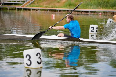 Yaz gününde nehirde genç atlet kürek çekmeye