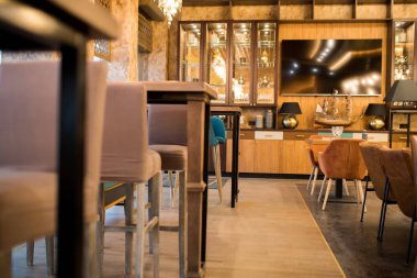 Altın renkte modern iç mekan: raflarda mobilya ve süslemeleri ile şık restoran, televizyon duvara asılı seti