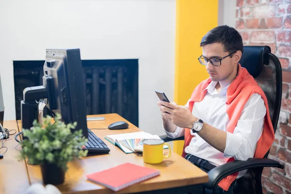 Homem Moderno Usando Smartphone Enquanto Senta Mesa Escritório Moderno Leve — Fotografia de Stock