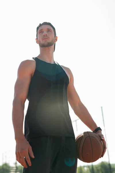 Retrato Baixo Ângulo Belo Jovem Desportista Segurando Bola Basquete Posando — Fotografia de Stock