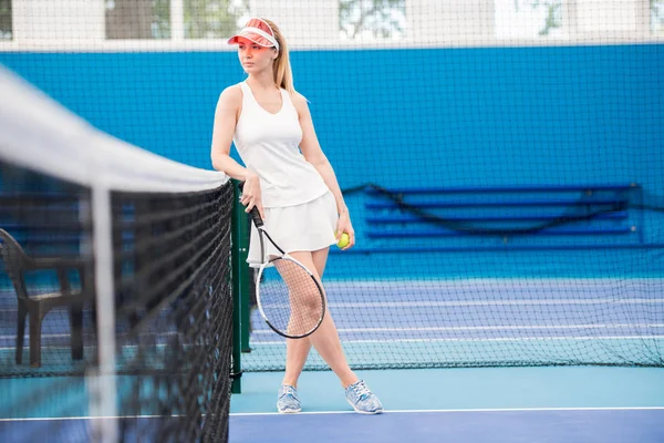 フルレングステニスコートに立っている物思い若い女性の肖像ネットに傾いて コピースペース — ストック写真