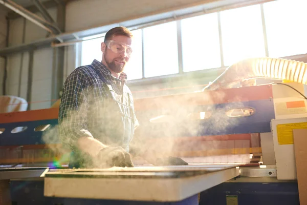 Lachende Bebaarde Fabrieks Medewerker Veiligheidsbril Staande Werkbank Werken Met Spaanplaat — Stockfoto