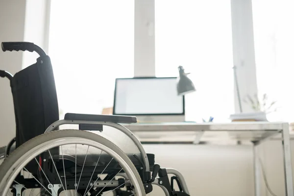 Wózek Inwalidzki Stojący Przy Biurku Monitorem Komputerowym Nowoczesnym Biurze — Zdjęcie stockowe