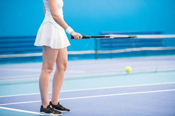 无法辨认的年轻女子拿着球拍 在室内球场打网球的低截面肖像 复制空间 — 图库照片