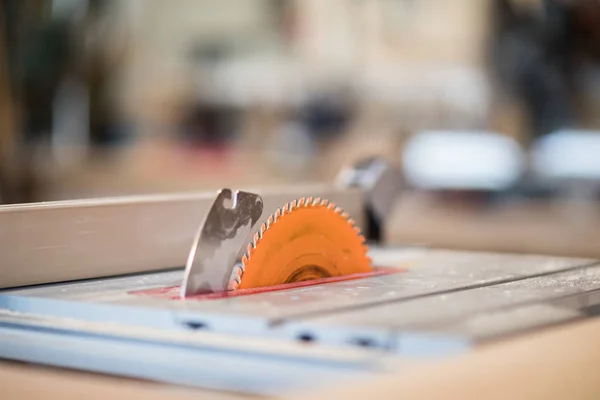 Close up of orange electric disk saw in  cutting machine unit in carpenters workshop, copy space
