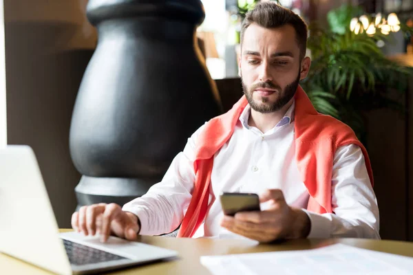 Portret Van Knappe Bebaarde Zakenman Houden Smartphone Typen Tekstberichten Tijdens — Stockfoto