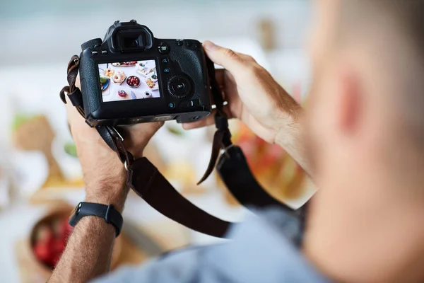 在观看无法辨认的摄影师拿着专业照片相机的画面上方 在桌子上拍摄食物的照片 复制空间 — 图库照片