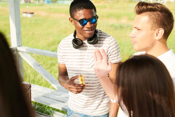 Vrolijke Jonge Afrikaanse Man Zonnebril Communiceert Met Zijn Vrienden Buitenshuis — Stockfoto