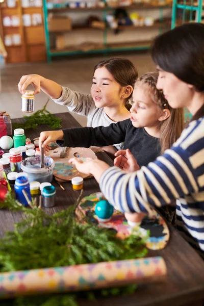 High angle  portrait of  children making Christmas decorations in crafting class with smiling  teacher, copy space