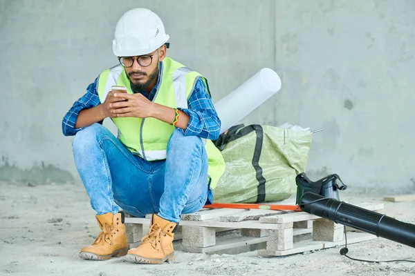 Pełna Długość Portret Bliskiego Wschodu Robotnik Budowlany Pomocą Smartfona Podczas — Zdjęcie stockowe