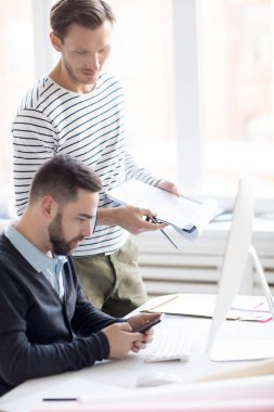 Modern ofiste çalışan gündelik giyim giymiş iki kişinin yan görünüm portresi