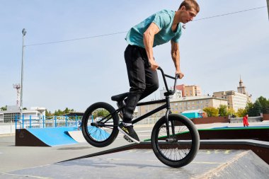 Kaykay parkta rampalarda sürme BMX stunts yapıyor yakışıklı genç adamın tam uzunlukta portre, kopya alanı