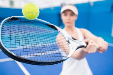 Kapalı mahkeme, kopya alanı spor oynarken raketi ile top vurmak kadın tenis oyuncusu yakın