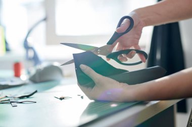 Atölyede gelecek çanta için makas ile deri kadın usta kesme parçası yakın çekim