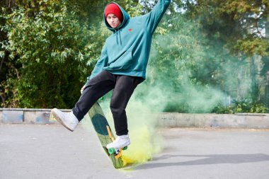 Yeşil duman, kopya uzay kaykay stunts yapıyor modern genç adam tam uzunlukta portre