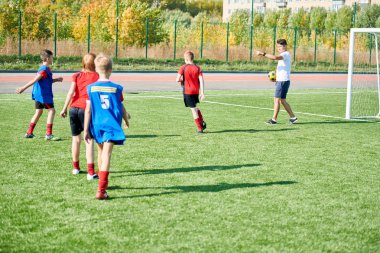 Genç futbol takımının geniş açı portresi, çocuklar için talimat veren Coach ile açık alan içinde pratik, boşluk kopyalama