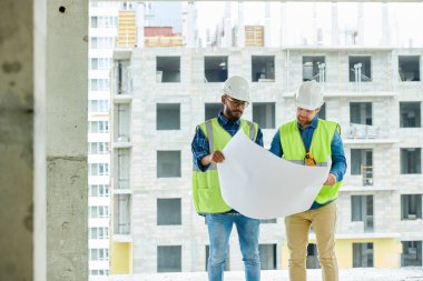 Şehirde inşaat süreci planlarken çizim görüntüleme Ciddi düşünceli yakışıklı erkek inşaat tasarımcıları