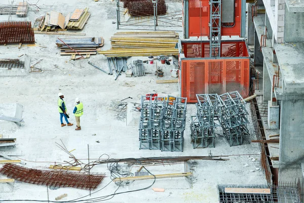 高層ビル コピースペースによるプロジェクトを議論2人の労働者と建設現場の広い角度ショット — ストック写真