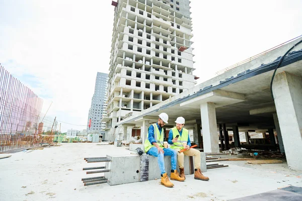 Positief Opgewonden Jonge Interraciale Ingenieurs Hardhats Vesten Zittend Plaat Lachen — Stockfoto