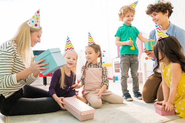 Positive Giovani Madri Attraenti Eccitati Bambini Carini Seduti Tappeto Indovinare — Foto Stock