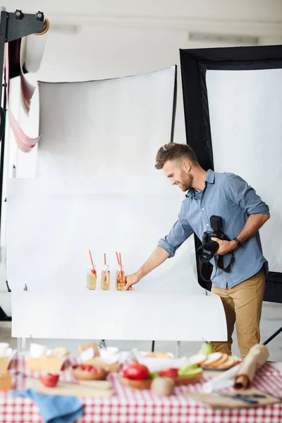 在拍摄物体和食物时 微笑摄影师安排饮料的侧视肖像 复制空间 — 图库照片