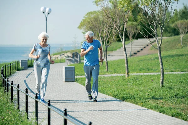 Full Length Portrait Active Senior Couple Running Park Lane Sea — Stock Photo, Image