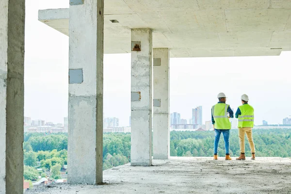 Вид Ззаду Сучасних Інженерів Робочому Одязі Стоять Краю Будівництва Обговорюють — стокове фото