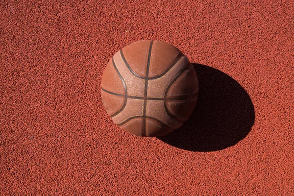 トップビュースポーツ オレンジバスケットボールボールの背景日光に照らされたコートフロアに横たわって コピースペース — ストック写真