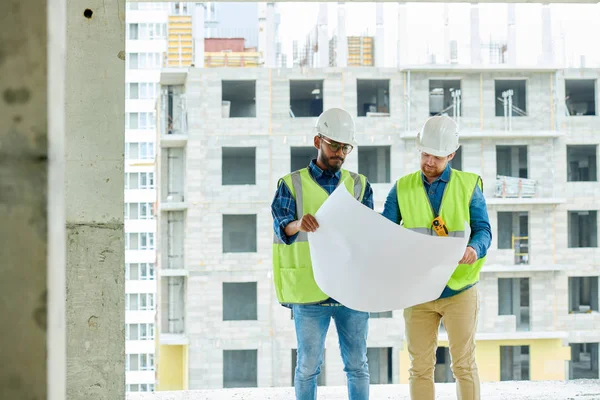 Şehirde inşaat süreci planlarken çizim görüntüleme Ciddi düşünceli yakışıklı erkek inşaat tasarımcıları