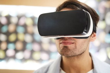 VR kulaklık ile genç adam meraklı video izlerken ya da boş zaman sanal dünyada seyahat