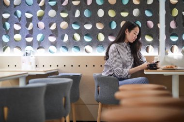 Üniversite kafede sınıfları arasında mola harcama sırasında akıllı telefon manifatura ile genç öğrenci