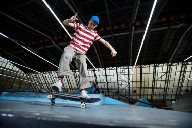 Parkour uygulama sırasında iniş doğru hareket ederken kaykay üzerinde duran yetenekli çocuk
