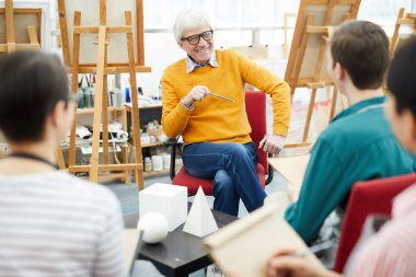Kolejde oturum çizme sırasında öğretmen dinleyen sanat öğrencileri grubunun portresi